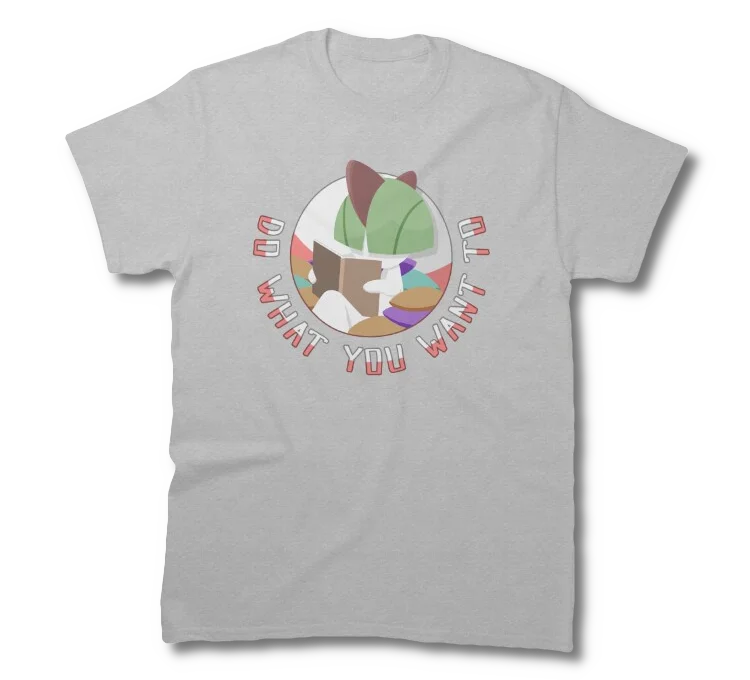 A shirt depicting a Ralts pokemon, sitting in a pile of cushions, reading a book, with the catchphrase around it reading 'Do What You Want To'