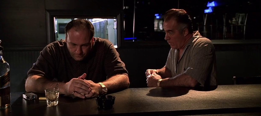 A screencap from the Sopranos, depicting Tony Soprano, who still sucks, and Pauly Walnuts, who also sucks